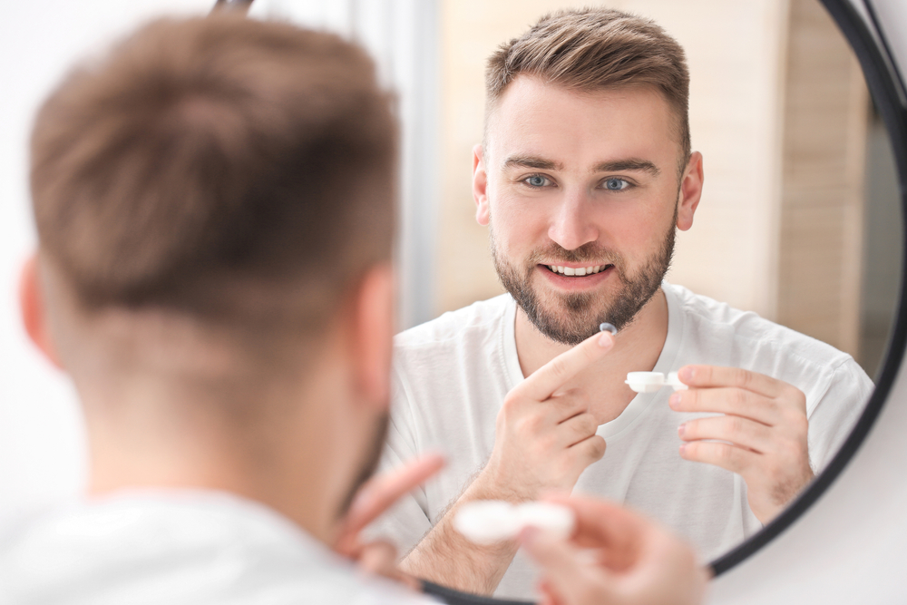 Man putting on his contact lenses - Eye Doctor Kentwood