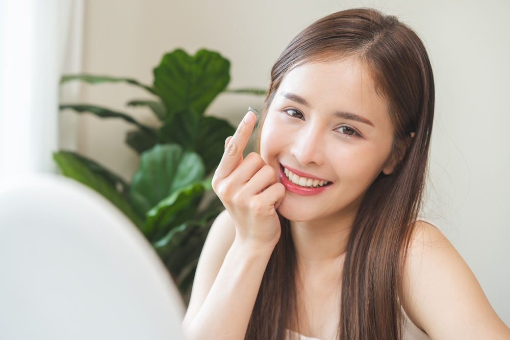 daily disposable contact lens on her face with finger - Contact Lenses in Grand Rapids